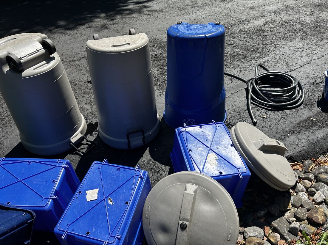 Garbage, recycling and compost bins lined up ready for cleaning